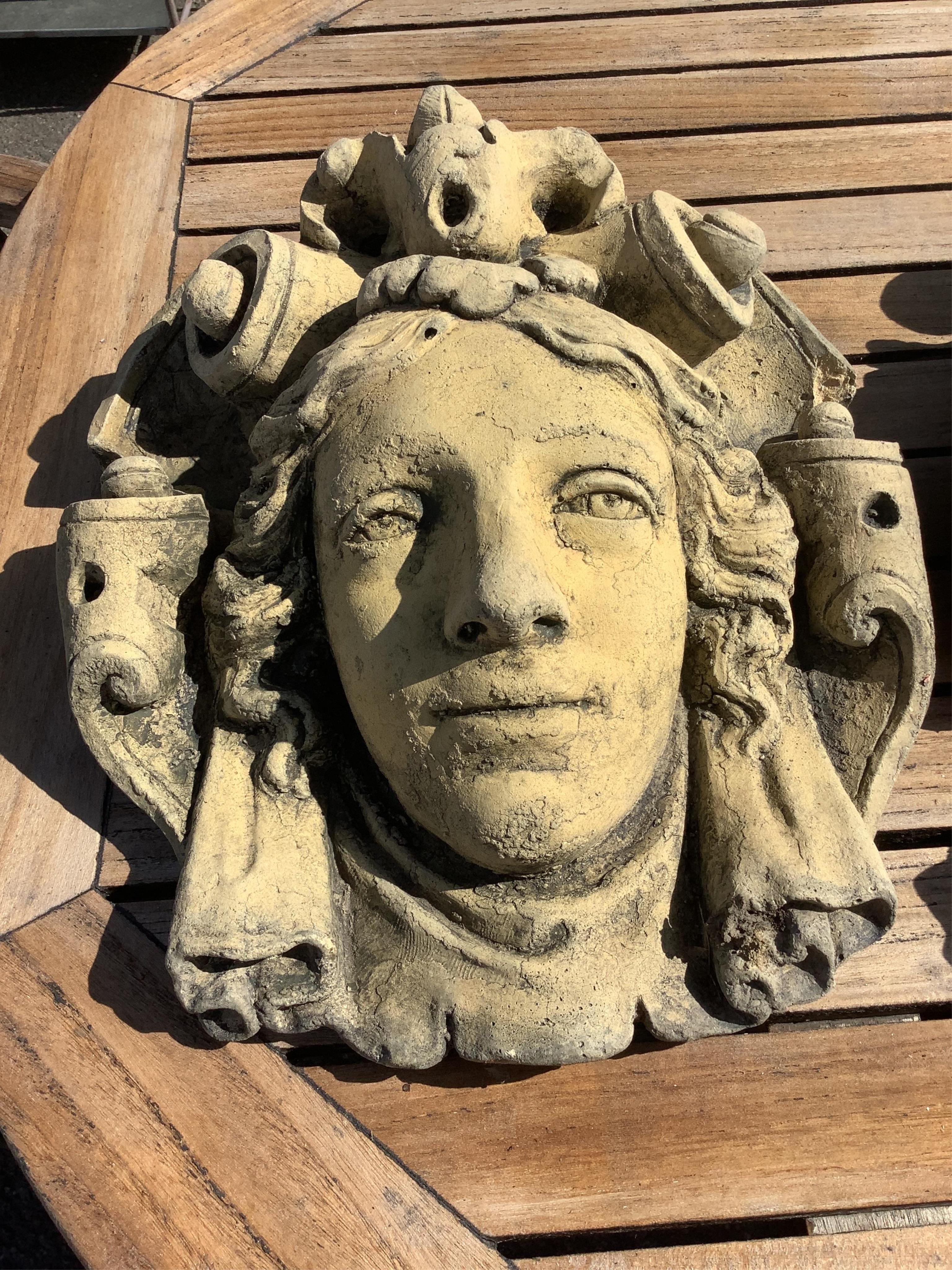 Three cast stone and terracotta garden wall mask appliqués, largest height 42cm